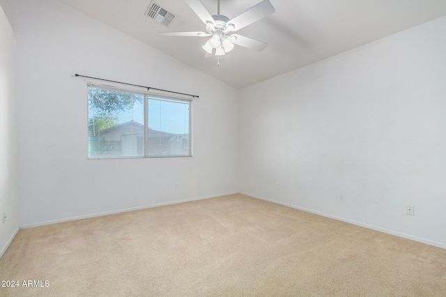 spare room with vaulted ceiling, light colored carpet, and ceiling fan