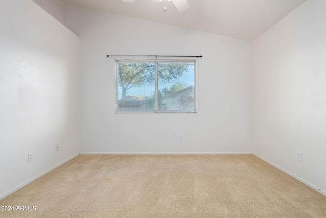 carpeted spare room featuring ceiling fan and vaulted ceiling