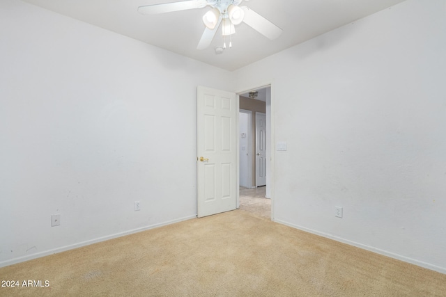 spare room with light colored carpet and ceiling fan