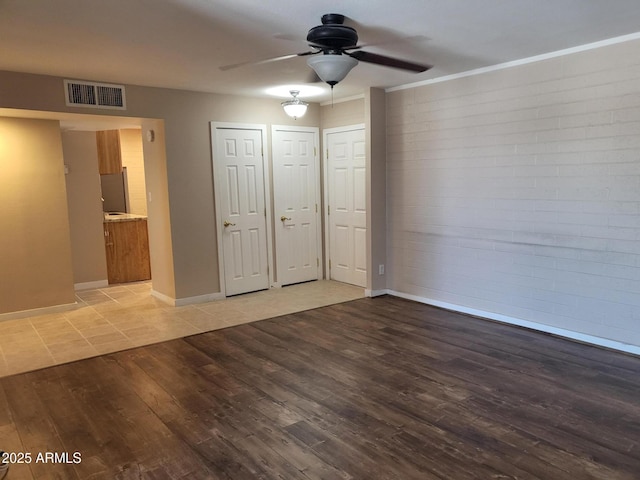 815 N Hayden Rd Unit A204, Scottsdale, AZ 85257 - unfurnished bedroom with light wood-style floors, two closets, brick wall, and ceiling fan