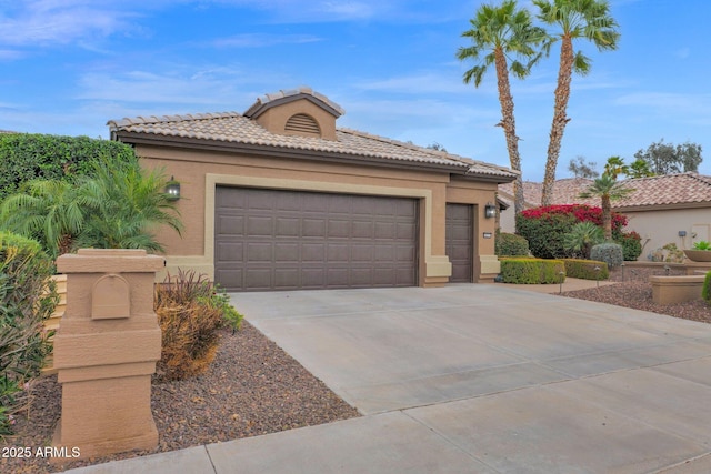 view of front of house with a tile roof, an attached garage, driveway, and stucco siding