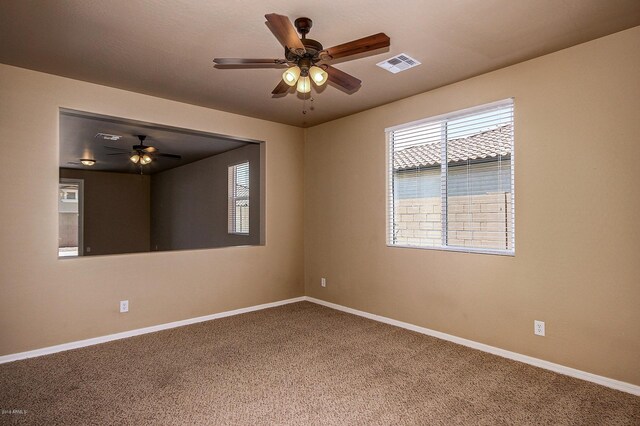 carpeted spare room featuring ceiling fan