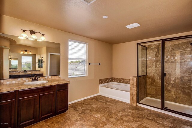 bathroom featuring vanity, separate shower and tub, and a wealth of natural light