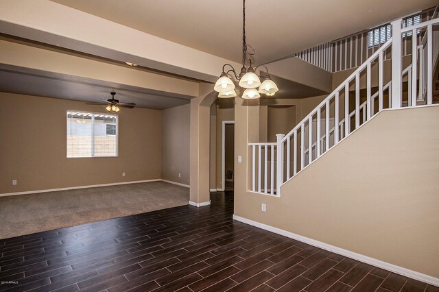 unfurnished living room featuring ceiling fan with notable chandelier