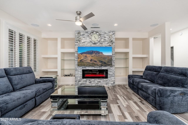 15583 W Big Sky Dr, Surprise, AZ 85374 - living room with ceiling fan, a fireplace, built in features, and wood-type flooring
