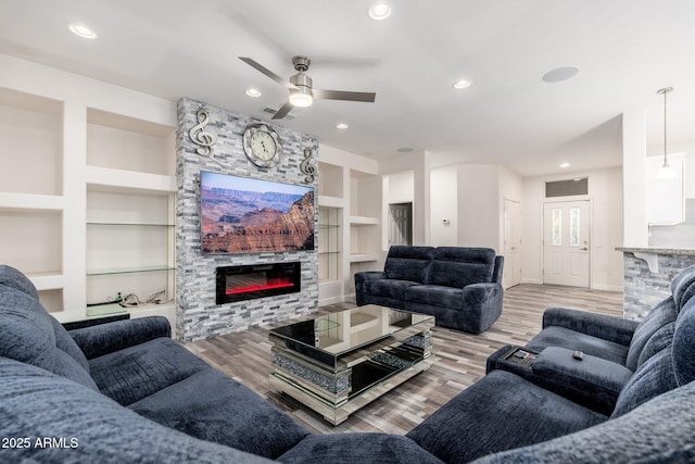 15583 W Big Sky Dr, Surprise, AZ 85374 - living room featuring ceiling fan, light wood-type flooring, a fireplace, and built in shelves