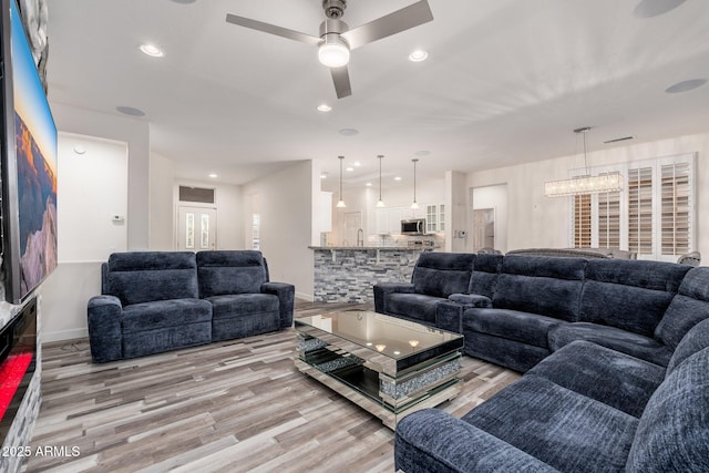 15583 W Big Sky Dr, Surprise, AZ 85374 - living room featuring ceiling fan with notable chandelier and light hardwood / wood-style floors