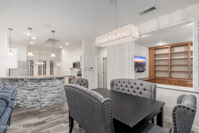 15583 W Big Sky Dr, Surprise, AZ 85374 - dining room with a chandelier, built in features, and light wood-type flooring