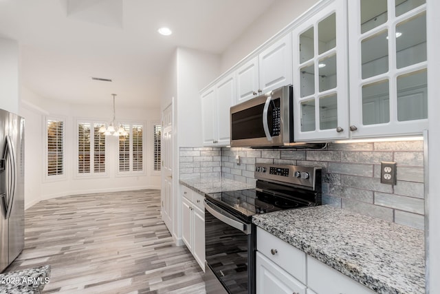 15583 W Big Sky Dr, Surprise, AZ 85374 - kitchen with appliances with stainless steel finishes, decorative light fixtures, decorative backsplash, and white cabinets