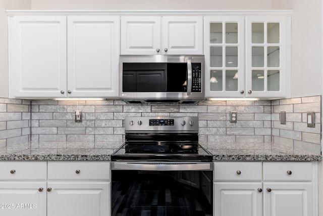 15583 W Big Sky Dr, Surprise, AZ 85374 - kitchen featuring range with electric cooktop, white cabinetry, stone countertops, and backsplash