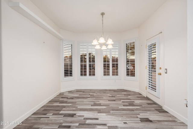 15583 W Big Sky Dr, Surprise, AZ 85374 - unfurnished dining area featuring an inviting chandelier, a healthy amount of sunlight, and light hardwood / wood-style flooring