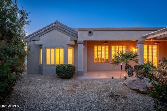 15583 W Big Sky Dr, Surprise, AZ 85374 - back house at dusk featuring ceiling fan and a patio area