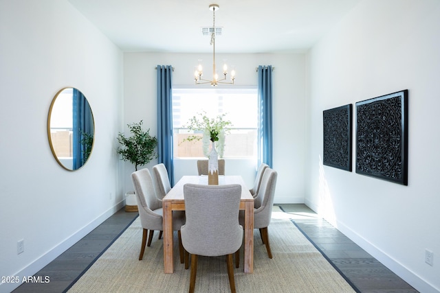 dining area featuring a chandelier, wood finished floors, baseboards, and visible vents