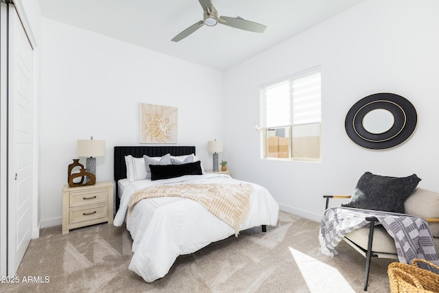 carpeted bedroom featuring a closet, baseboards, and ceiling fan