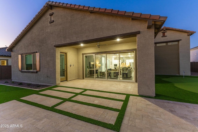 rear view of property with a patio, stucco siding, and a tile roof