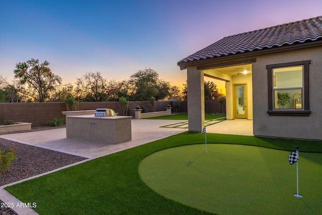 view of yard featuring a patio, a fenced backyard, and exterior kitchen