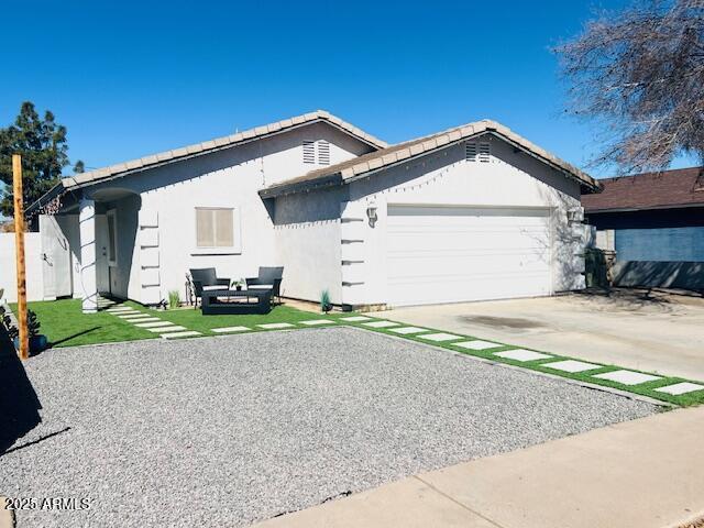 6128 W Palmaire Ave, Glendale, AZ 85301 - single story home featuring a garage, concrete driveway, stucco siding, and a tiled roof