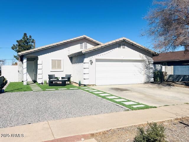 6128 W Palmaire Ave, Glendale, AZ 85301 - ranch-style house featuring an attached garage, driveway, stucco siding, and a tile roof