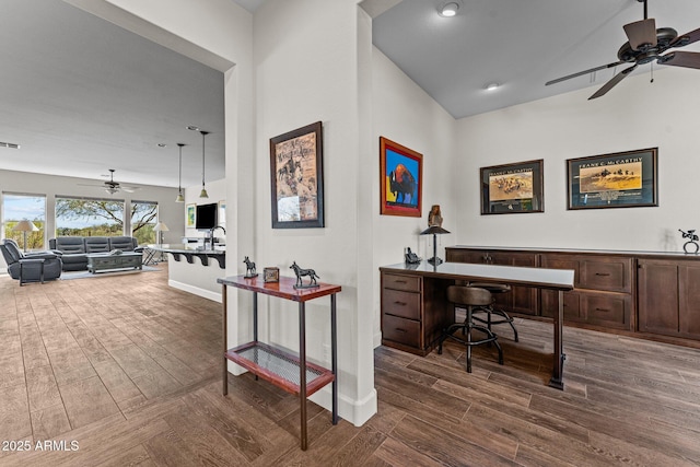 office space featuring lofted ceiling, visible vents, dark wood-style flooring, and ceiling fan