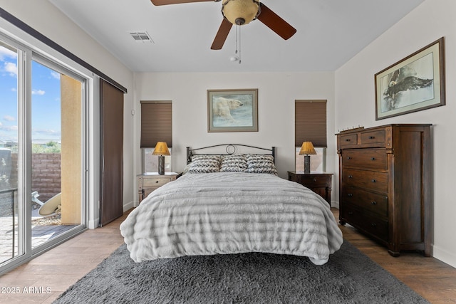 bedroom with access to exterior, visible vents, baseboards, wood finished floors, and a ceiling fan