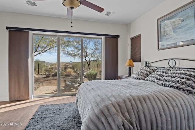 bedroom featuring access to outside, wood finished floors, visible vents, and ceiling fan