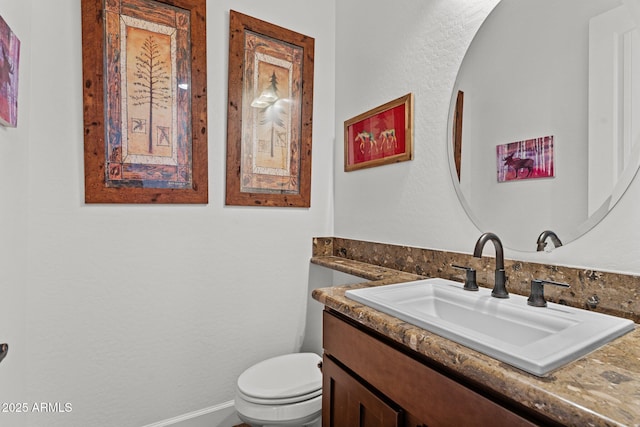 half bathroom with toilet, vanity, and baseboards