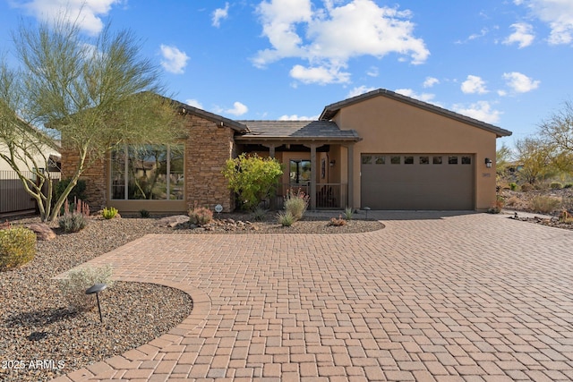 single story home with decorative driveway, an attached garage, stucco siding, and a tile roof