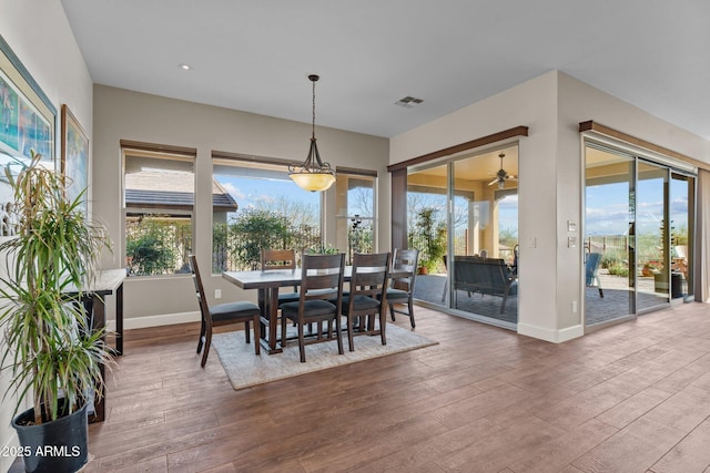 dining area featuring visible vents, a healthy amount of sunlight, baseboards, and dark wood-style flooring