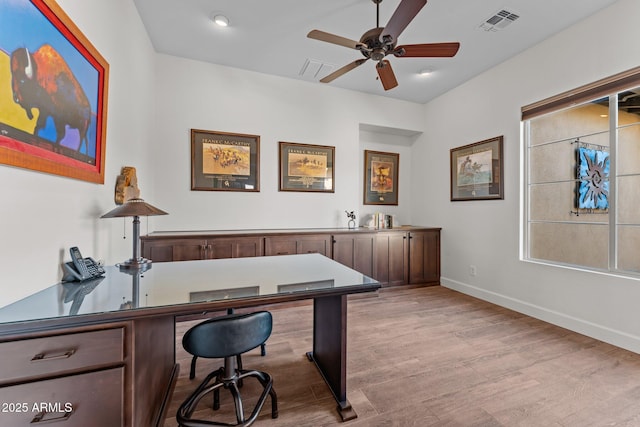 office with a healthy amount of sunlight, a ceiling fan, visible vents, baseboards, and light wood-style flooring