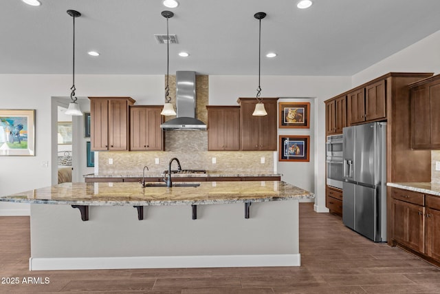 kitchen featuring stainless steel appliances, a breakfast bar area, wall chimney exhaust hood, and dark wood finished floors