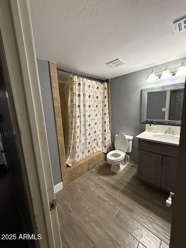 6429 W Palm Ln, Phoenix, AZ 85035 - full bath featuring wood finish floors, a textured ceiling, vanity, and shower / bath combination with curtain