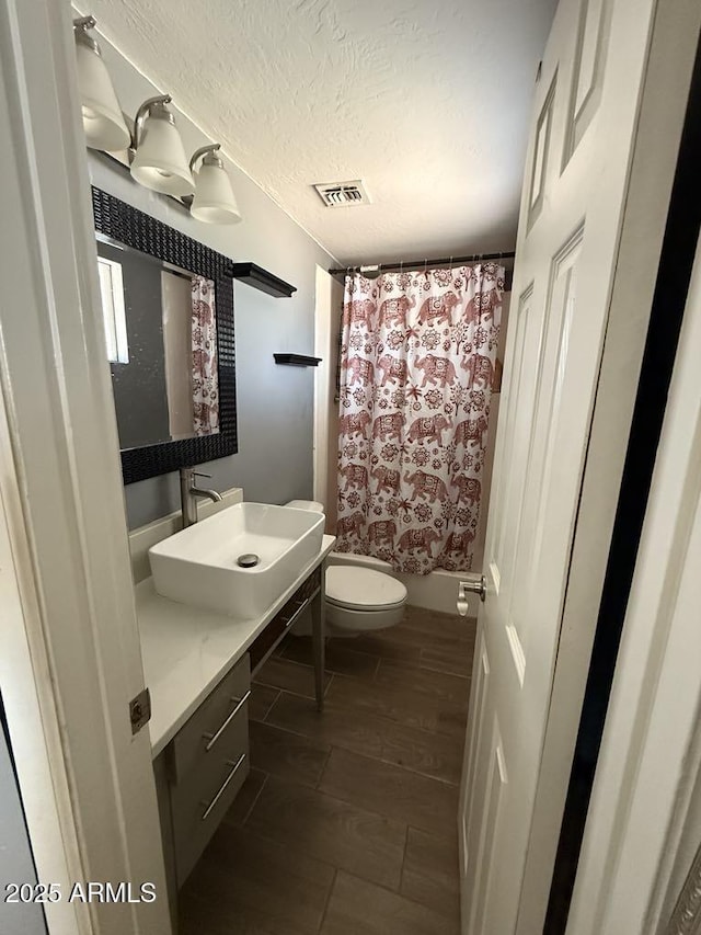 6429 W Palm Ln, Phoenix, AZ 85035 - full bathroom featuring vanity, wood finished floors, and a textured ceiling