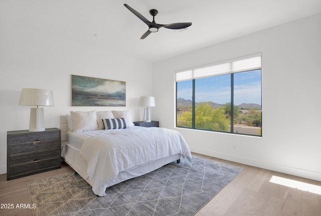 bedroom featuring a ceiling fan, wood finished floors, and baseboards