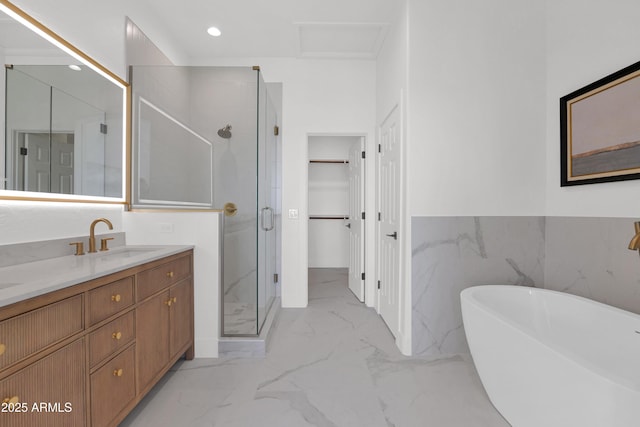 full bath with marble finish floor, vanity, a stall shower, a spacious closet, and a soaking tub