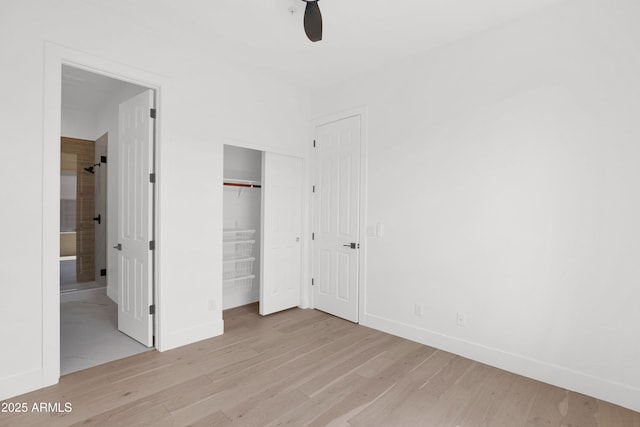 unfurnished bedroom featuring light wood-style floors, ensuite bathroom, and baseboards