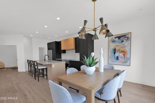dining space featuring baseboards, light wood-style floors, and recessed lighting