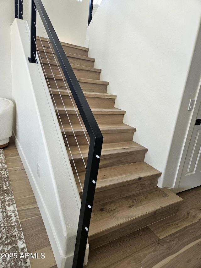 stairs featuring baseboards and wood finished floors