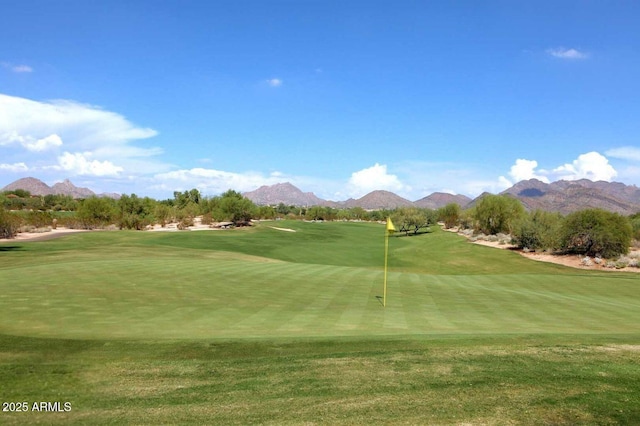 surrounding community with a lawn, golf course view, and a mountain view
