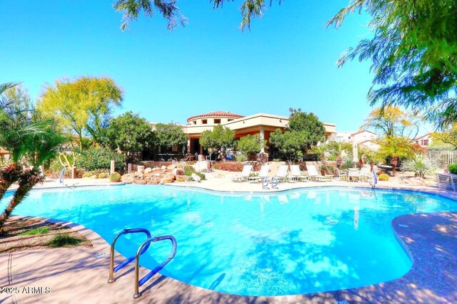 outdoor pool featuring a patio and fence