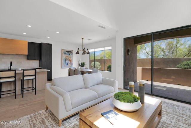 living area featuring recessed lighting, visible vents, and light wood-style floors