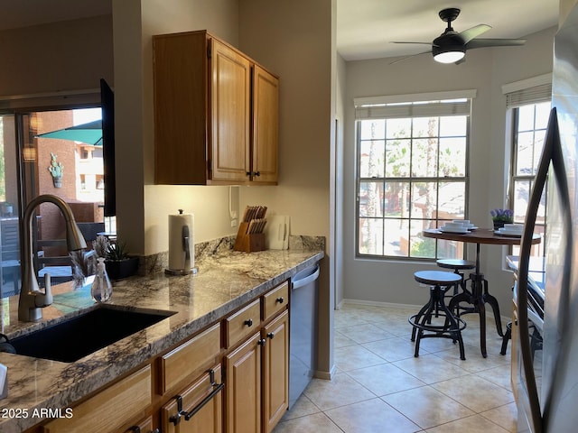 kitchen featuring a sink, ceiling fan, healthy amount of natural light, and light tile patterned flooring