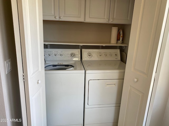 laundry area with washing machine and clothes dryer and cabinet space