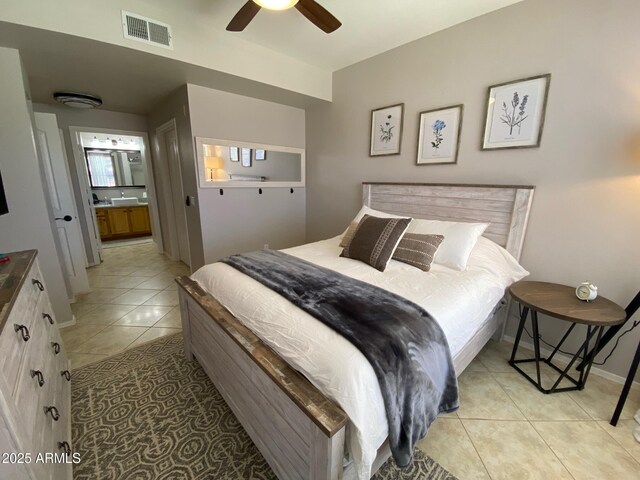 bedroom with light tile patterned floors, connected bathroom, baseboards, and ceiling fan