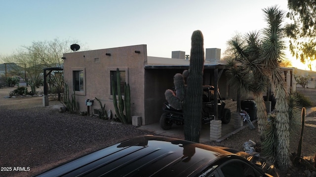 exterior space with a patio area, stucco siding, and cooling unit