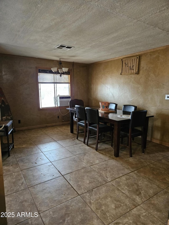 dining room featuring an inviting chandelier, baseboards, visible vents, and a textured ceiling