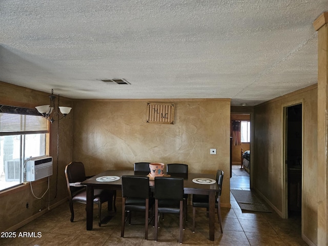 dining area with visible vents, a notable chandelier, a healthy amount of sunlight, and a textured ceiling