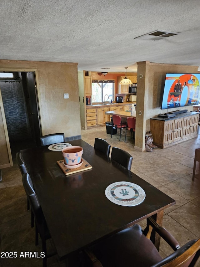 dining area with visible vents and a textured ceiling