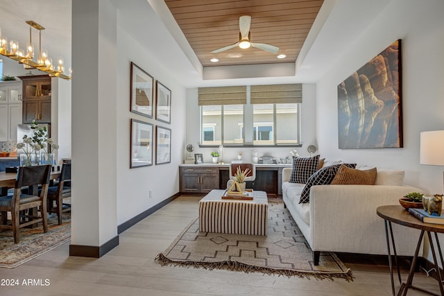 living room featuring ceiling fan with notable chandelier, wood ceiling, a raised ceiling, and light hardwood / wood-style flooring