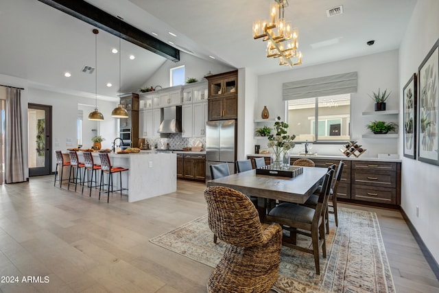 dining area featuring a wealth of natural light, light wood-type flooring, and lofted ceiling with beams