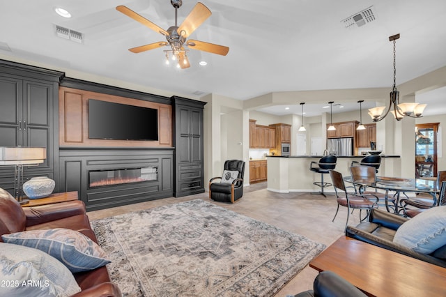 living area with a glass covered fireplace, visible vents, and recessed lighting